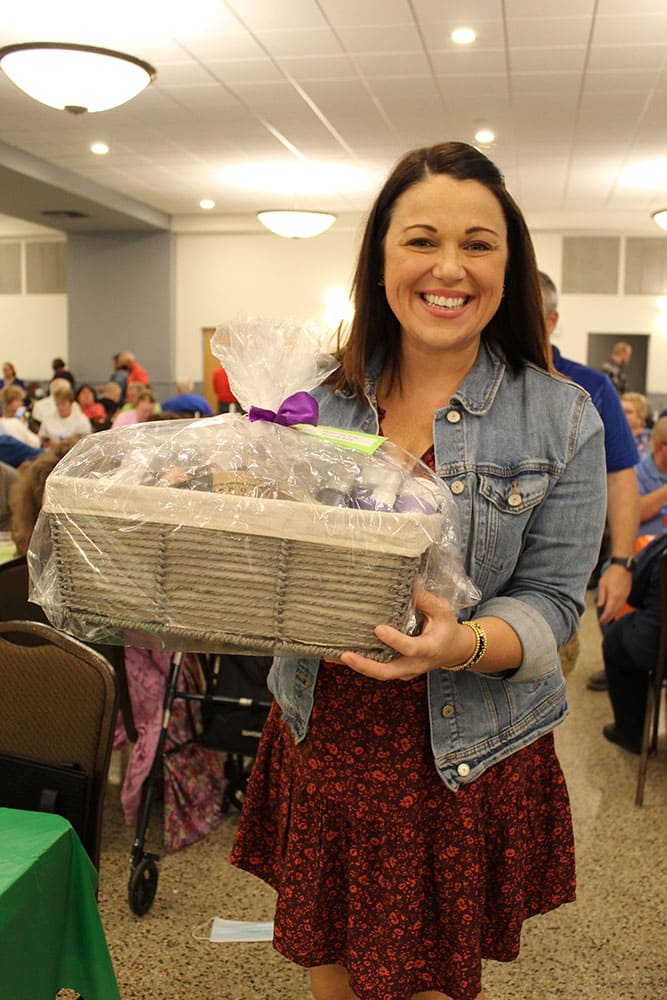 A guest holds a prize basket at Bingo Night