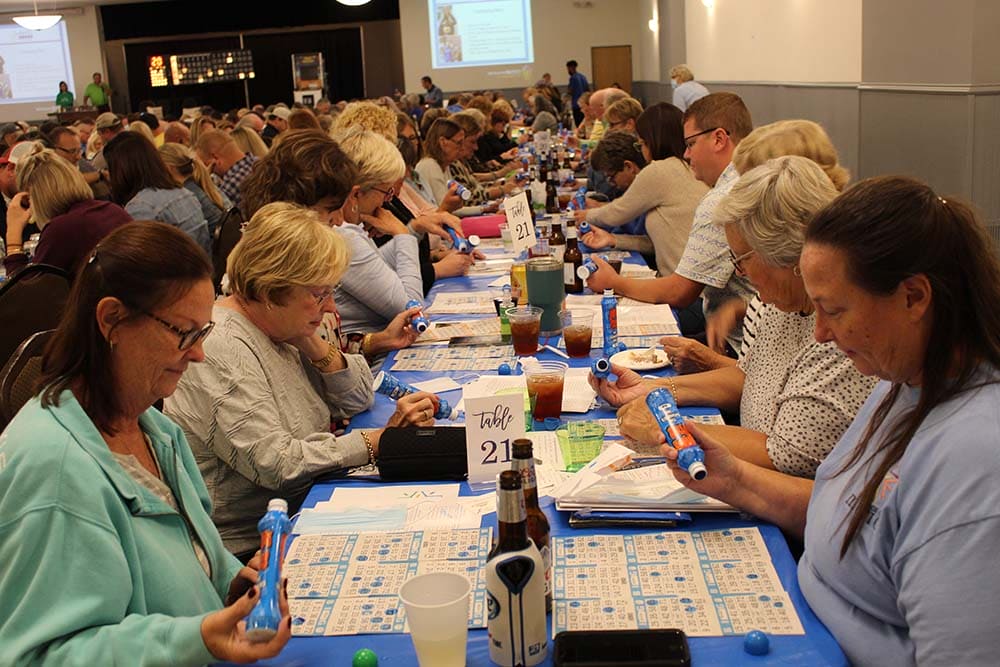 Guests playing bingo at long tables