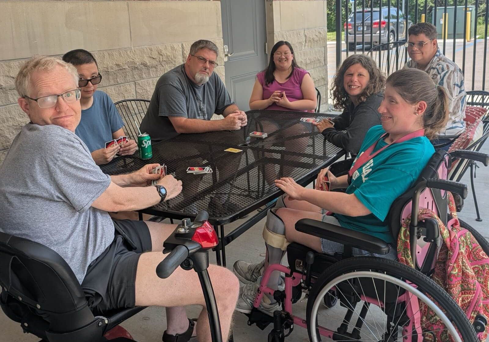 Residents playing a card game together at a patio table outside The Brunette