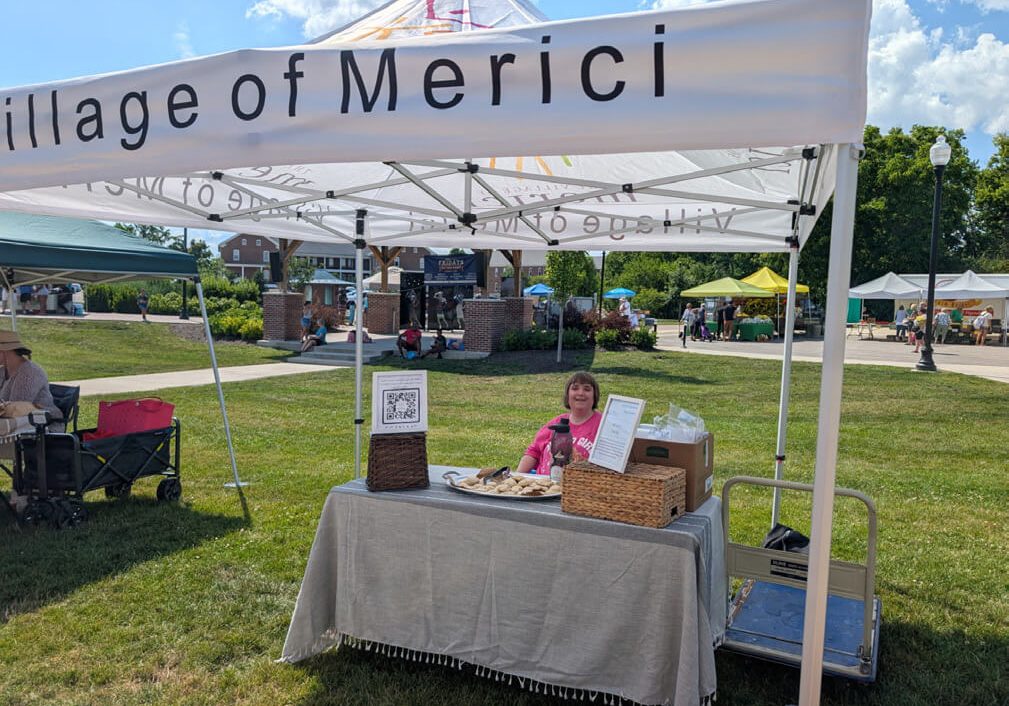 The Village of Merici booth at the Lawrence Farmers Market