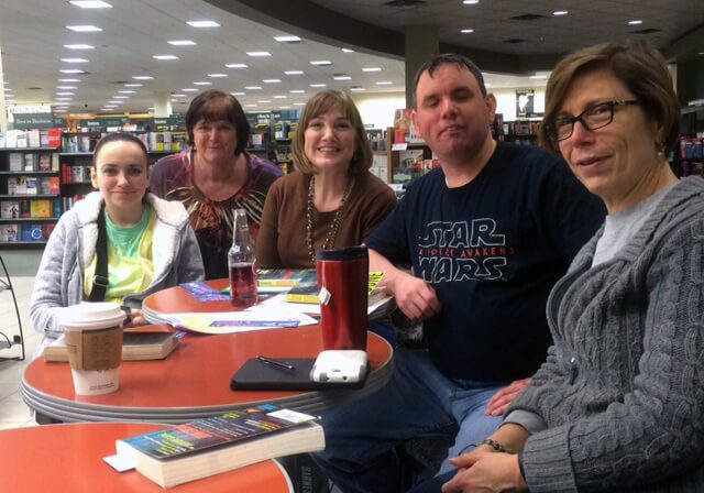 Village of Merici book club members gathered around a table at a bookstore