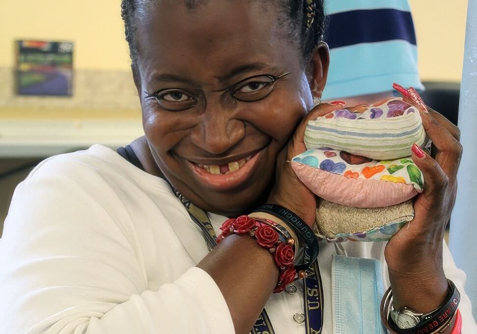 A Village of Merici resident holding a handmade craft project